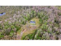 Beautiful aerial view of home nestled on wooded lot with mature trees and in-ground pool at 13024 Mohican Ave, New Port Richey, FL 34654