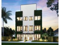 Stunning three-story home featuring lush green walls, expansive windows, and a modern architectural design at 145 5Th N Ave, St Petersburg, FL 33701
