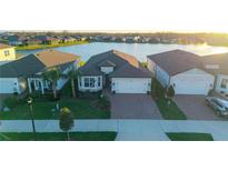 Beautiful single Gathering home showcasing a brick paved drive, meticulous landscaping, and tranquil waterfront views at 19742 Sea Glass Cir, Land O Lakes, FL 34638