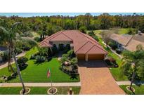 Beautiful single-story home featuring well-manicured lawn, mature landscaping, brick driveway and terra cotta tile roof at 370 Tall Oak Trl, Tarpon Springs, FL 34688