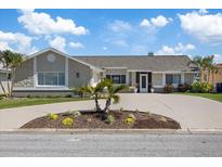 Charming single-story home with stone accents, mature landscaping, and a circular driveway at 5000 Galleon Ct, New Port Richey, FL 34652
