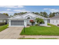 Charming single-story home featuring a well-maintained lawn, beautiful landscaping, and an attached two-car garage at 6329 Cardinal Crest Dr, New Port Richey, FL 34655