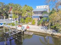 Waterfront home featuring a private dock, multiple stories, and a screened porch at 8721 Old Post Rd, Port Richey, FL 34668
