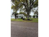 Well-maintained home with a lush green lawn, mature trees, and manicured landscaping at 11121 Linkside Dr # 11121, Port Richey, FL 34668