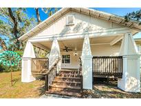 Inviting front porch with wooden stairs, columns and railings on a charming two-story home, creating a warm, welcoming entrance at 120 Read St, Tarpon Springs, FL 34689