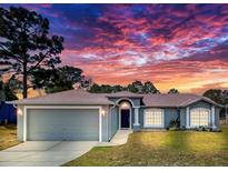 Charming single story home with an attached garage and manicured lawn under a dramatic sky at 2165 Bolger Ave, Spring Hill, FL 34609