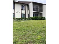 Building 508 with manicured green lawn and dark framed windows and doors at 2688 Pine Ridge N Way # D2, Palm Harbor, FL 34684