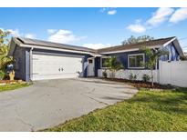 Charming blue home featuring solar panels, a spacious driveway, and well-maintained landscaping at 5590 77Th N Ave, Pinellas Park, FL 33781