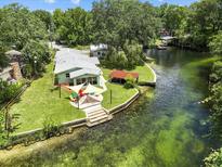 Stunning aerial view of the waterfront home with a patio and direct access to the beautiful, clear river at 6090 Waverly Rd, Weeki Wachee, FL 34607
