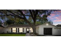 Charming single-story home with white brick, black accents, and a well-manicured lawn at 1120 Westwood Dr, Lutz, FL 33549
