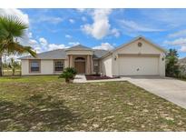 Inviting single-story home with a two-car garage and a well-maintained front yard at 13140 Maycrest Ave, Weeki Wachee, FL 34614