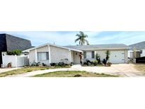 Charming single-story home featuring a stone facade, attached garage, and well-maintained landscaping at 4030 Grayton Dr, New Port Richey, FL 34652