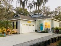 Charming single-story home with a blue door, well-manicured lawn, and welcoming curb appeal at 513 Meres Blvd, Tarpon Springs, FL 34689