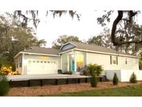 Charming single-Gathering home featuring an attached garage, well-maintained landscaping, and a welcoming front porch at 513 Meres Blvd, Tarpon Springs, FL 34689