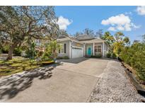 Charming single-story home with a well-manicured lawn, blue door, and spacious driveway at 513 Meres Blvd, Tarpon Springs, FL 34689
