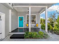 Inviting front porch with a bright blue door and charming decor at 513 Meres Blvd, Tarpon Springs, FL 34689