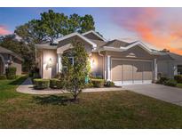 Charming home featuring manicured landscaping, neutral stucco, and attached two-car garage at 5492 Legend Hills Ln, Spring Hill, FL 34609