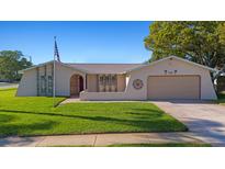 Charming single-story home featuring a well-manicured lawn and attached garage at 7901 Willow Brook Ct, Hudson, FL 34667