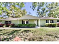 Charming single-story home featuring a manicured lawn, mature trees, and a welcoming front porch at 8715 Christi Ct, Tampa, FL 33637