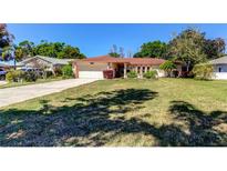 Charming single-story home with a well-maintained lawn, attached garage, and colorful landscaping at 9925 Whitworth Ct, New Port Richey, FL 34655