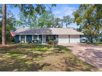 Charming single-story home with a well-maintained lawn, brick driveway, and a two-car garage at 1267 Meredith Dr, Spring Hill, FL 34608