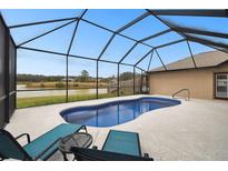 Enjoy this home's private screened-in pool with beautiful water view, perfect for relaxing or entertaining guests at 18317 Treehaven Dr, Hudson, FL 34667
