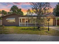 Charming home featuring a manicured lawn, a white picket fence, and lovely exterior lighting at 3728 Linkwood St, New Port Richey, FL 34652