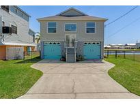 Two-story home featuring a two-car garage with blue doors and a well-maintained front yard at 4046 Casa Ct, Hernando Beach, FL 34607