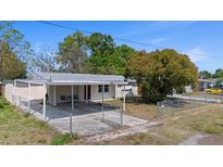 Charming single-story home featuring a covered carport and fenced front yard on a sunny day at 4743 Foothill Dr, Holiday, FL 34690