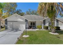 Charming single-story home boasts a well-manicured lawn, beautiful landscaping, and a welcoming facade at 7305 Sugarbush, Spring Hill, FL 34606