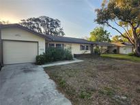 Charming single-story home with a one car garage and a traditional front yard landscape at 10803 Hachita Dr, Port Richey, FL 34668
