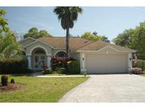 Charming single-story home with a two-car garage, mature landscaping, and a welcoming front entrance at 11480 Emerald Ridge Ct, Spring Hill, FL 34609