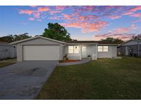 Charming single-story home with a well-manicured lawn and an attached garage at 1721 Kenilworth St, Holiday, FL 34691