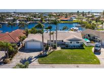 Waterfront home with lush landscaping, tile roof, and private boat dock on a sunny day at 3616 Harborview Ct, New Port Richey, FL 34652