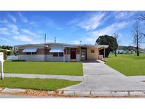 Charming single-story home featuring a well-maintained lawn, covered front entrance, and a long driveway at 4938 Azalea Dr, New Port Richey, FL 34652