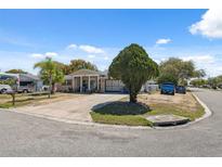 Charming one-story home featuring a well-maintained lawn and a circular driveway at 7514 Bergamot Dr, Port Richey, FL 34668