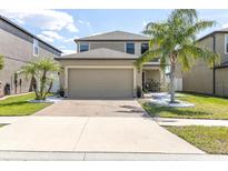 Charming two-story home with lush landscaping, a brick driveway and a two car garage at 11895 Crestridge Loop, New Port Richey, FL 34655