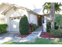 Charming home with a well-maintained lawn and landscaped front entrance, including a one-car garage at 2568 W Brook Ln, Clearwater, FL 33761