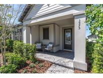 Inviting covered front porch with stylish seating and a paved walkway to the front door at 3975 Night Star Trl, Odessa, FL 33556