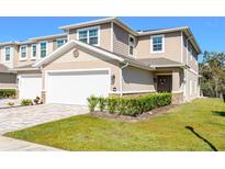 Charming two-story townhome featuring an attached garage, neutral color palette, and well-maintained landscaping at 5360 Riverwalk Preserve Dr, New Port Richey, FL 34653