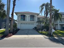 Two-story home featuring a 2-car garage, arched balconies and well manicured landscaping at 5956 Seaside Dr, New Port Richey, FL 34652