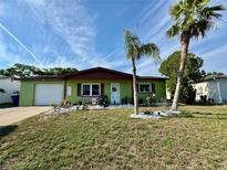 Charming single Gathering home showcasing a landscaped front yard and attached single car garage at 8053 Hixton Dr, Port Richey, FL 34668