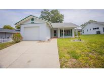 Charming single-story home with a well-maintained lawn, complemented by vibrant landscaping at 8121 Casuarina Dr, Port Richey, FL 34668