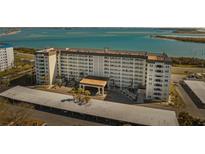 Aerial view of a waterfront condo building with covered parking and tropical landscaping at 9 Forbes Pl # 512, Dunedin, FL 34698