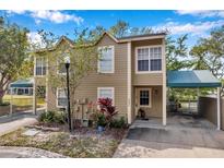 Inviting two-story home with cozy carport, lush landscaping, and a well-maintained exterior at 9046 Lake Place Ln # 9046, Tampa, FL 33634