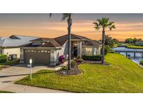Charming single-story home with a two-car garage, a manicured lawn, and waterfront access at 1809 Westerham Loop, Trinity, FL 34655