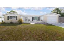 Charming single-story home featuring a well-manicured lawn and a welcoming front entrance with decorative concrete fencing at 2620 Baltic Pl, Holiday, FL 34691