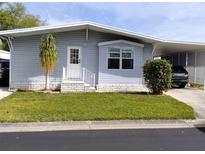 Charming single-story home with light blue siding, well-manicured lawn and covered carport at 34135 Brown Bayou, Wesley Chapel, FL 33543