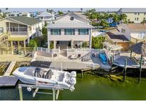 Waterfront home featuring a boat lift, a dock, lush landscaping, and multiple outdoor spaces for relaxing and entertaining at 4058 Centavo Ct, Hernando Beach, FL 34607