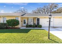 Charming yellow home with a well-manicured lawn and a cozy front porch area perfect for enjoying the outdoors at 4831 Wakefield Ct, New Port Richey, FL 34655